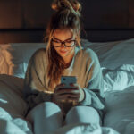 Woman On Phone In Hotel Room Bed