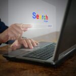 A man is using a notebook computer to searching for information. A virtual screen of the Search website browser for finding data on the internet. Global network, search engine optimization technology