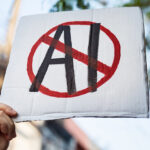 Demonstrator holding "No AI" placard